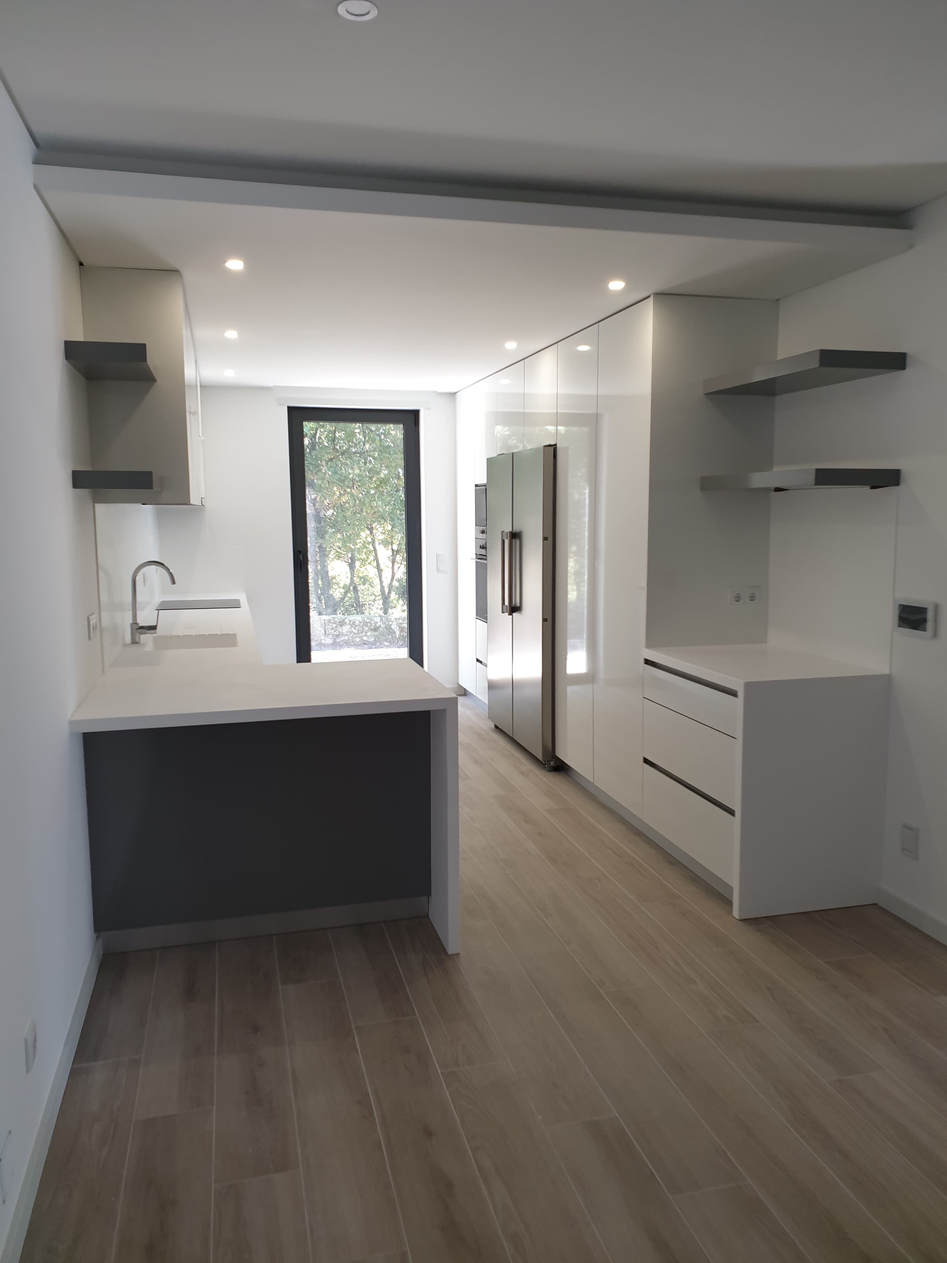 Cozinha contemporânea com armários brancos, apontamentos escuros e uma ilha central